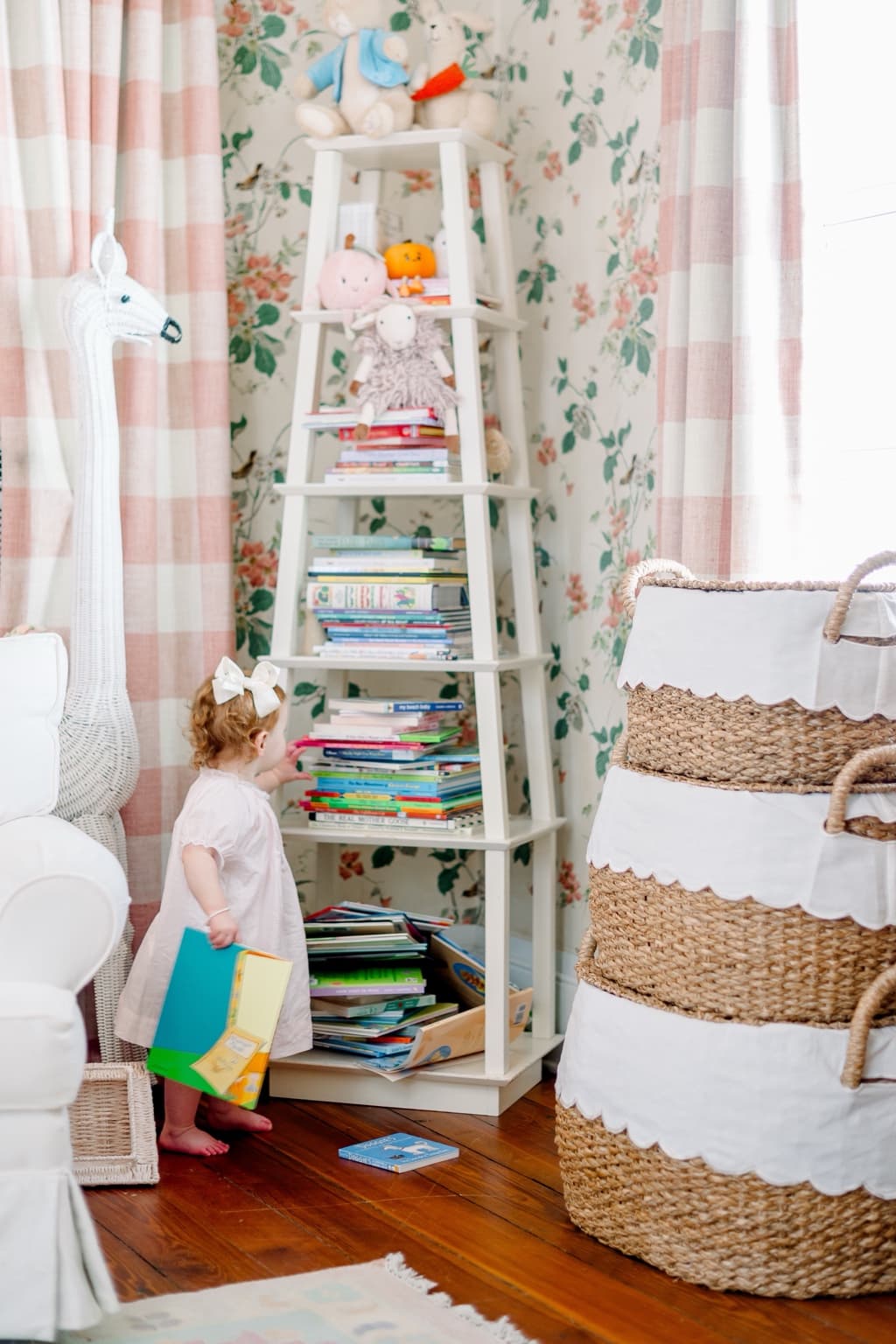 A nursery corner with layered baskets, books, and soft decorative details.